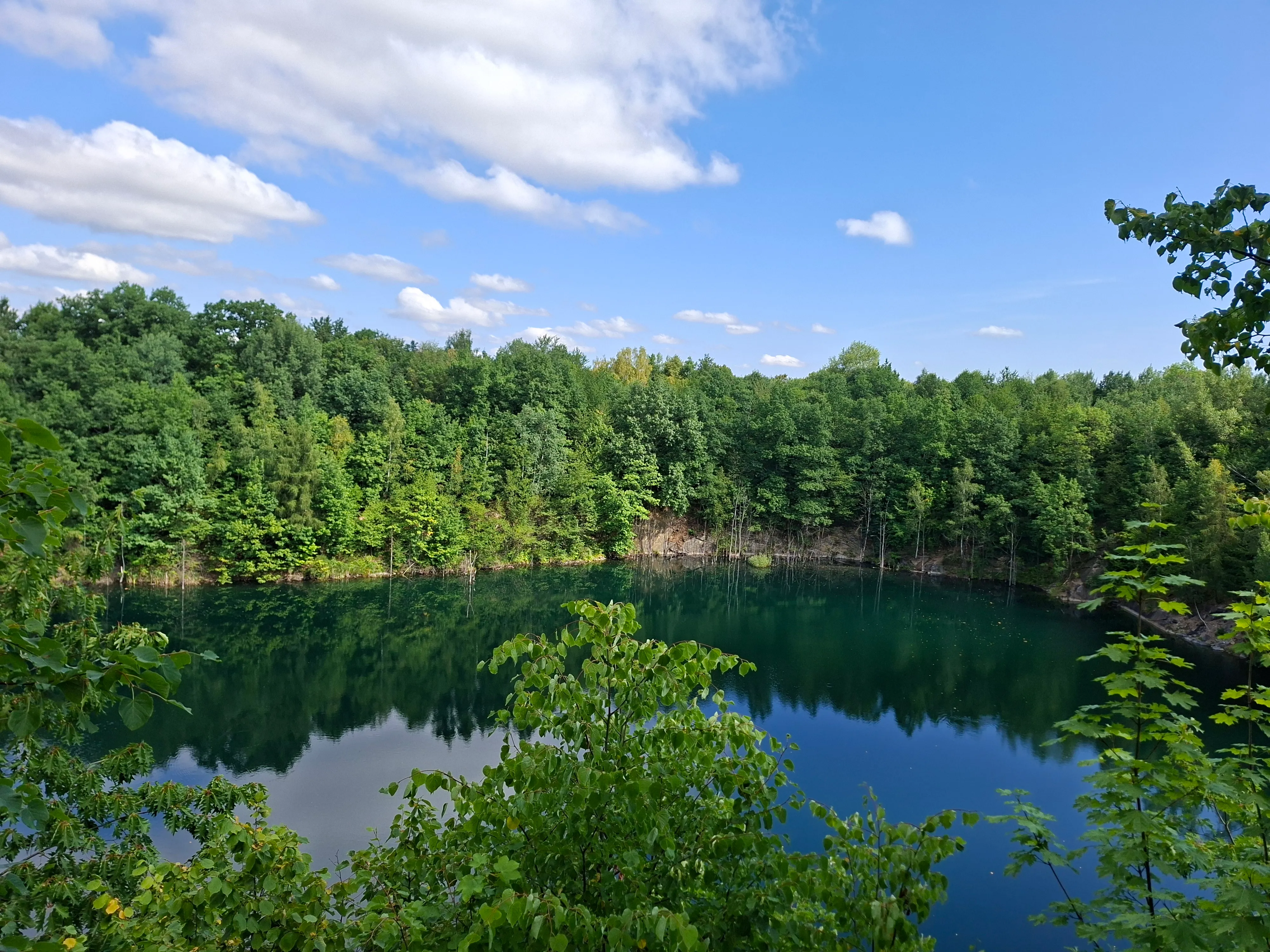 Submerged quarry with small ladder leading to water in foreground